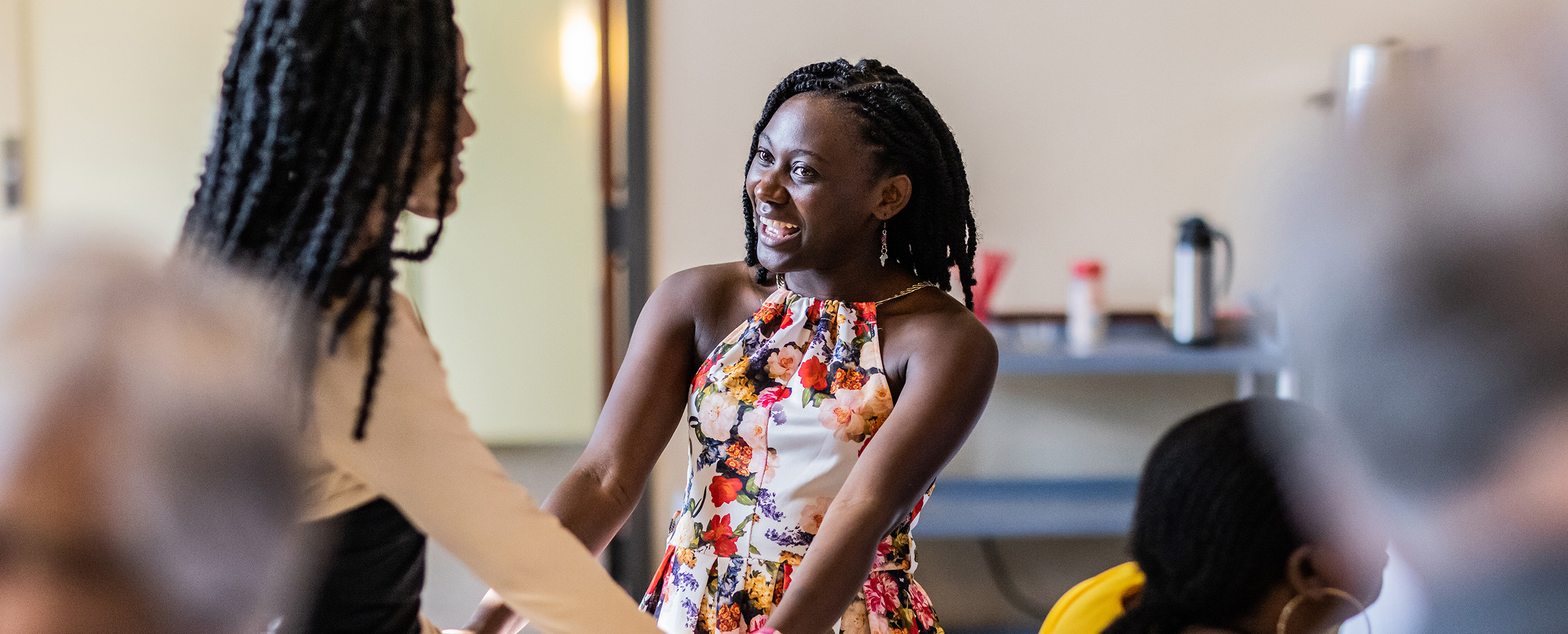 Emillie Binja smiling at a woman she is greeting.